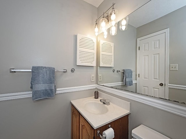 half bathroom with vanity and toilet