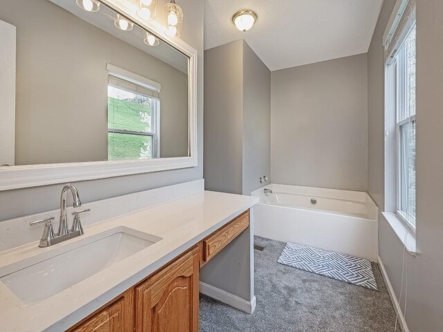 full bathroom with baseboards, vanity, and a garden tub