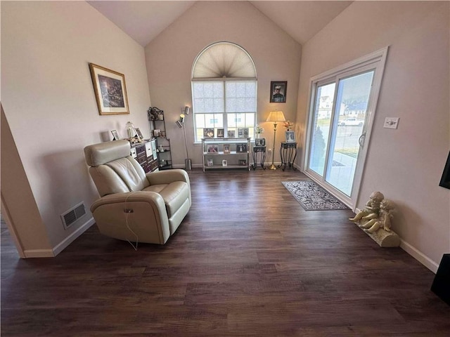 sitting room featuring dark wood-style floors, lofted ceiling, visible vents, and baseboards