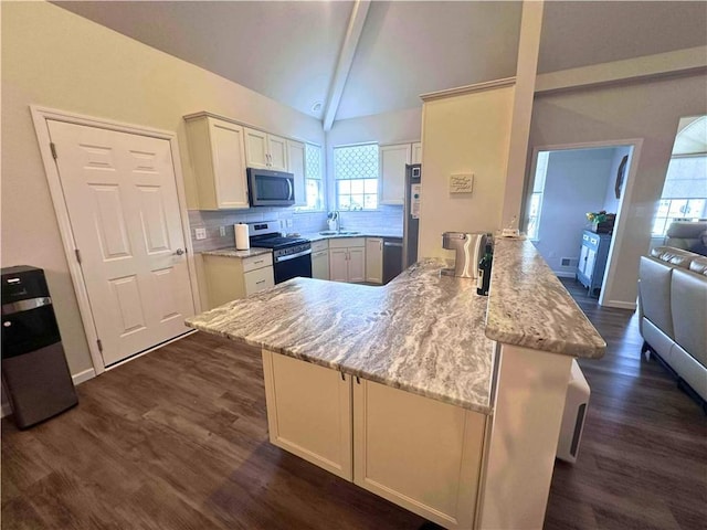 kitchen featuring dark wood finished floors, backsplash, appliances with stainless steel finishes, white cabinetry, and a peninsula