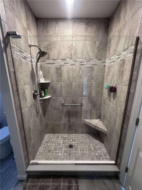 full bathroom with a stall shower and toilet