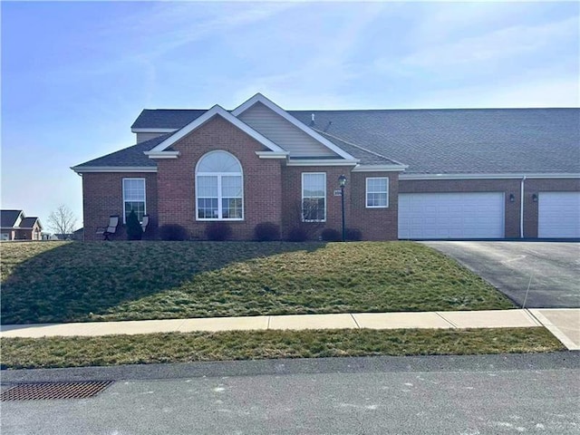 view of front of property with a garage, driveway, brick siding, and a front yard