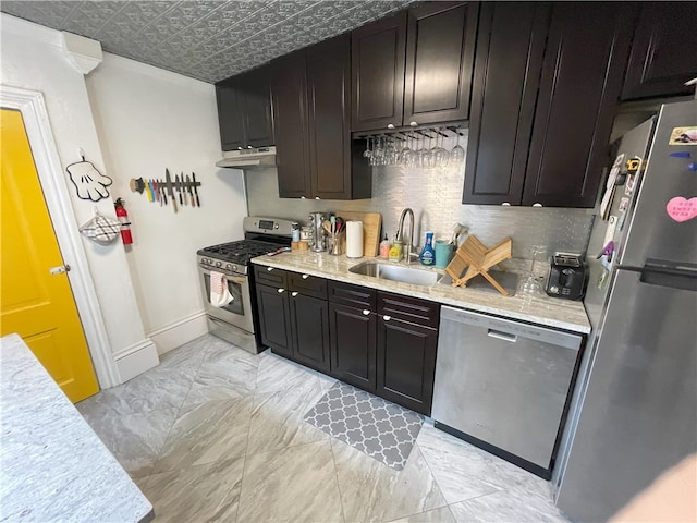 kitchen with under cabinet range hood, stainless steel appliances, a sink, tasteful backsplash, and an ornate ceiling