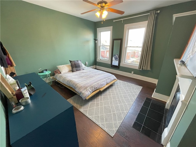 bedroom featuring dark wood-style floors, ceiling fan, and baseboards