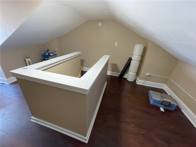 additional living space featuring lofted ceiling, baseboards, and dark wood-type flooring