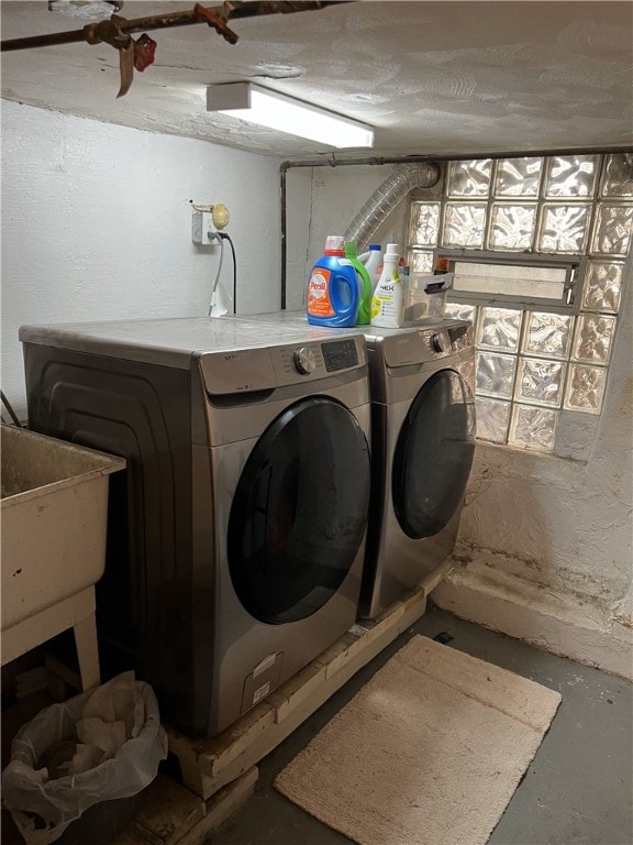 laundry room featuring a textured ceiling, laundry area, and washer and clothes dryer