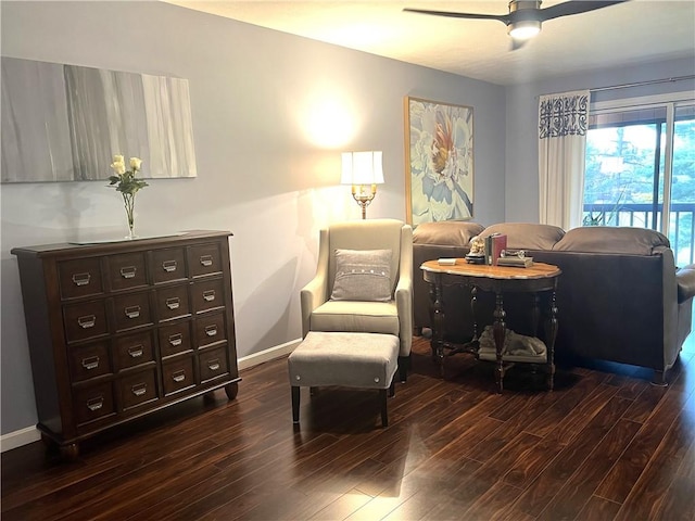 sitting room with baseboards, dark wood finished floors, and a ceiling fan