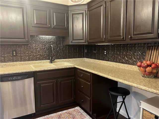 kitchen featuring dishwasher, light countertops, tasteful backsplash, and a sink