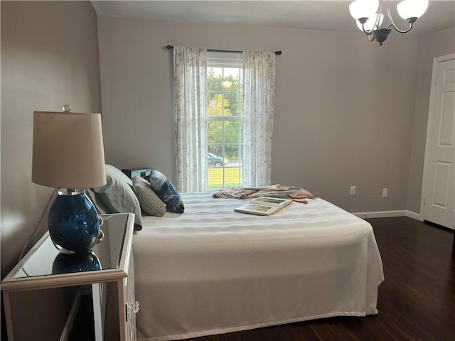 bedroom featuring dark wood-style floors, baseboards, and a chandelier