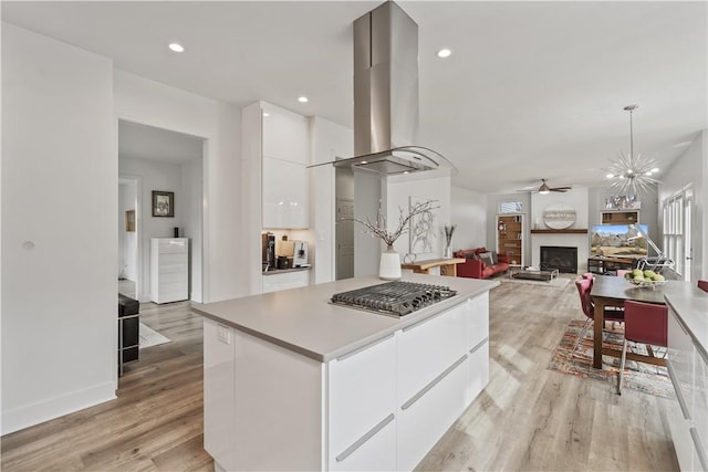 kitchen featuring white cabinets, light wood-style flooring, island range hood, and modern cabinets