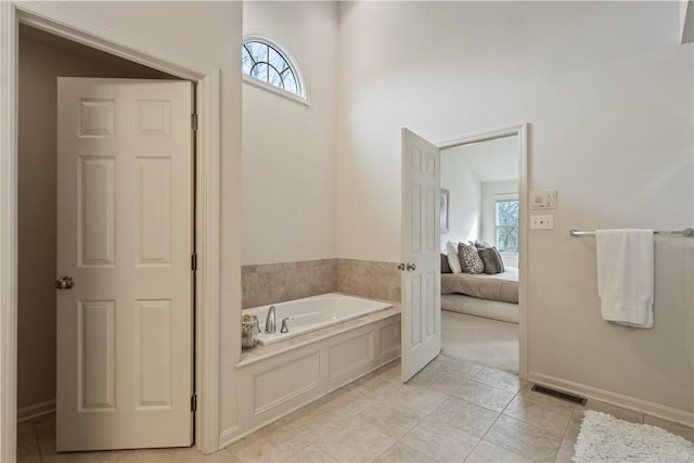 ensuite bathroom featuring a garden tub, visible vents, connected bathroom, baseboards, and tile patterned floors