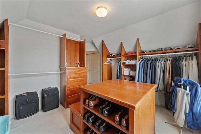 spacious closet featuring vaulted ceiling and light colored carpet