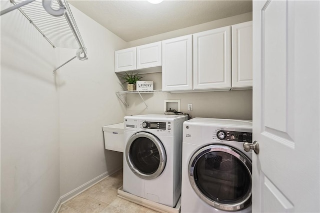 laundry room with cabinet space, independent washer and dryer, baseboards, and light tile patterned flooring