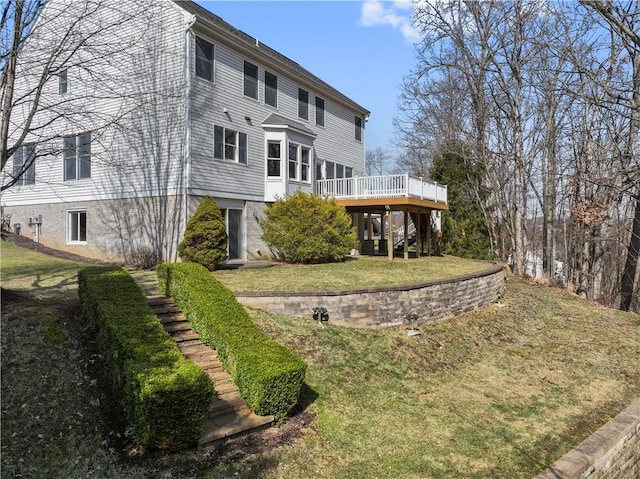 back of property featuring stairway, a lawn, and a wooden deck