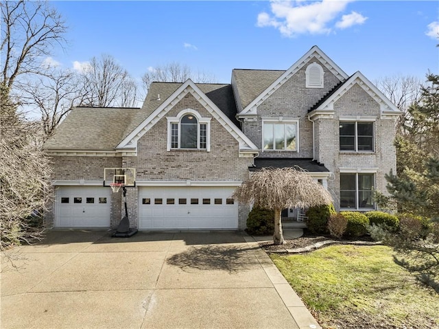 traditional-style home featuring driveway, a garage, roof with shingles, a front lawn, and brick siding