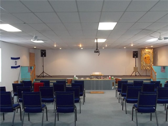 interior space with a paneled ceiling and carpet floors