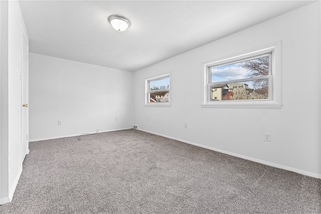 carpeted spare room featuring baseboards