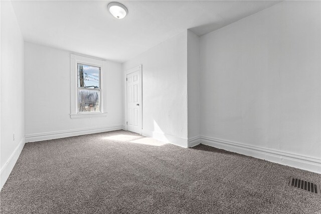 unfurnished room featuring baseboards, visible vents, and carpet flooring