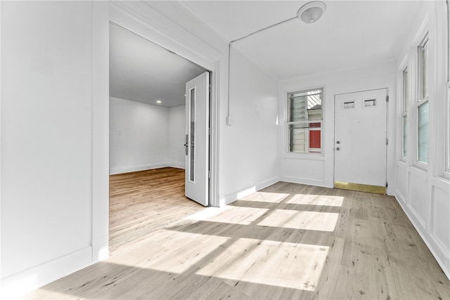 foyer featuring light wood finished floors and baseboards