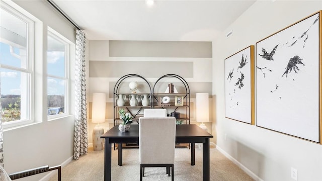 carpeted dining area featuring baseboards