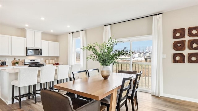 dining space featuring light wood-style flooring, baseboards, and recessed lighting