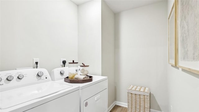 laundry area with laundry area, light wood-type flooring, baseboards, and washing machine and dryer