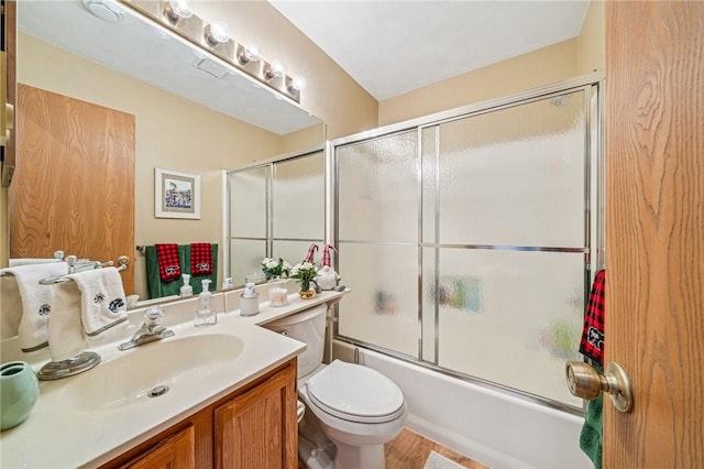 full bath featuring combined bath / shower with glass door, vanity, and toilet