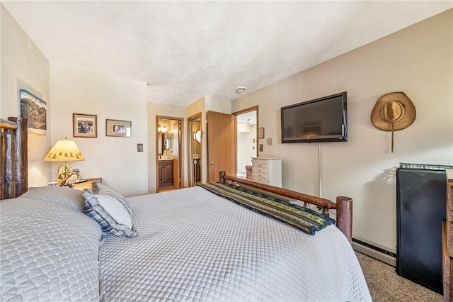 bedroom with ensuite bath, carpet, and baseboard heating