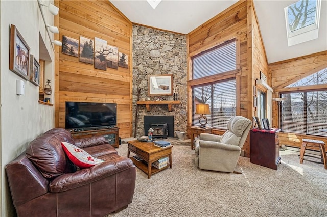 living room featuring high vaulted ceiling, a skylight, carpet flooring, and wooden walls