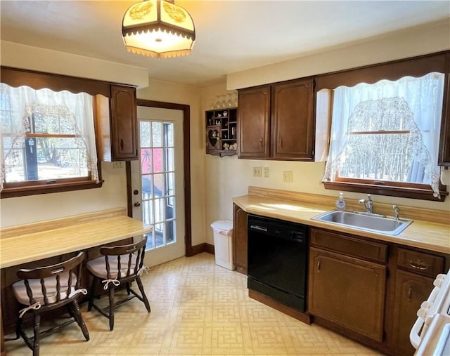 kitchen with a sink, light countertops, range, dishwasher, and light floors