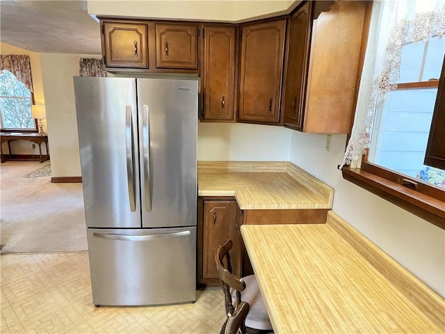 kitchen featuring baseboards, light countertops, and freestanding refrigerator