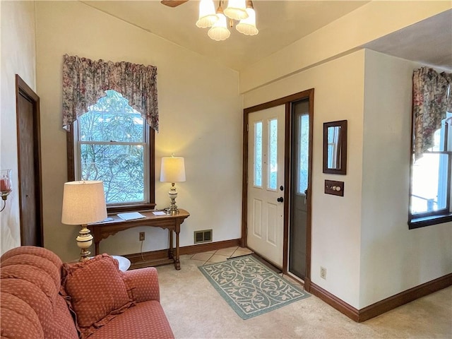 carpeted entrance foyer featuring visible vents and baseboards