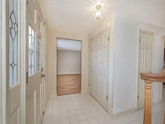 entryway with light tile patterned floors and baseboards