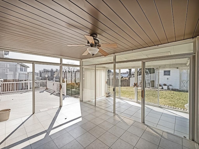 unfurnished sunroom featuring wood ceiling and a ceiling fan