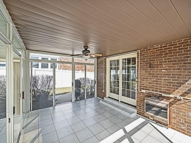 unfurnished sunroom with heating unit, wooden ceiling, and a ceiling fan