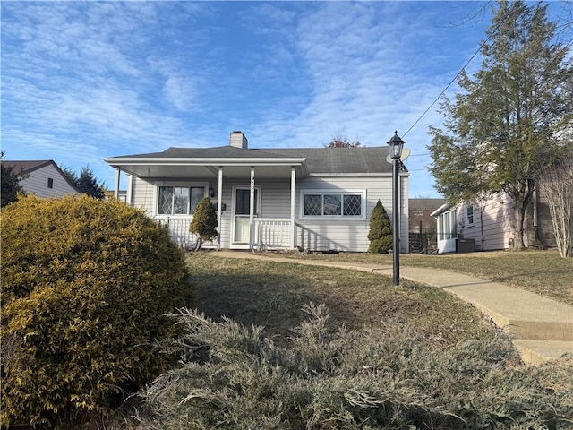 bungalow-style house featuring covered porch and a chimney