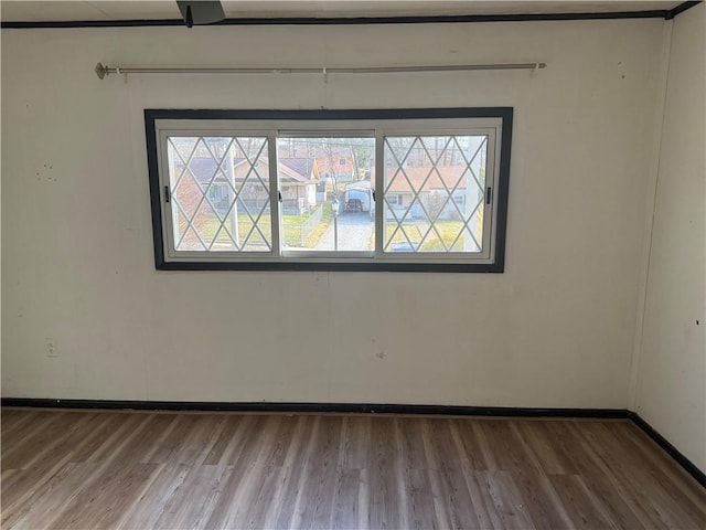 empty room with baseboards and wood finished floors