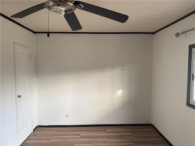 unfurnished room with ceiling fan, baseboards, wood finished floors, and crown molding