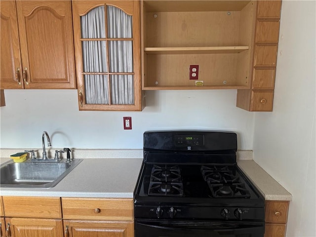 kitchen with light countertops, a sink, black gas range oven, and open shelves