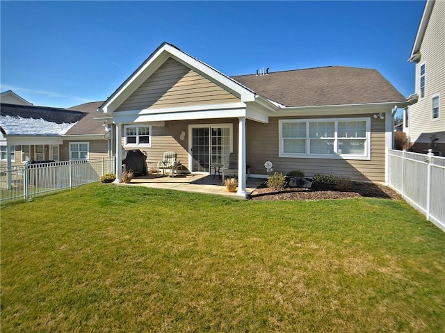 rear view of house with a patio area, a fenced backyard, and a yard