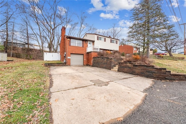 view of front of home with brick siding, driveway, a chimney, and an attached garage