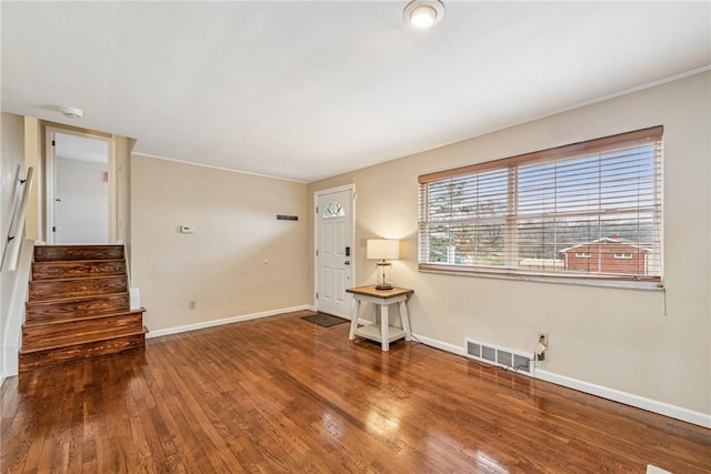 interior space with stairs, wood finished floors, visible vents, and baseboards