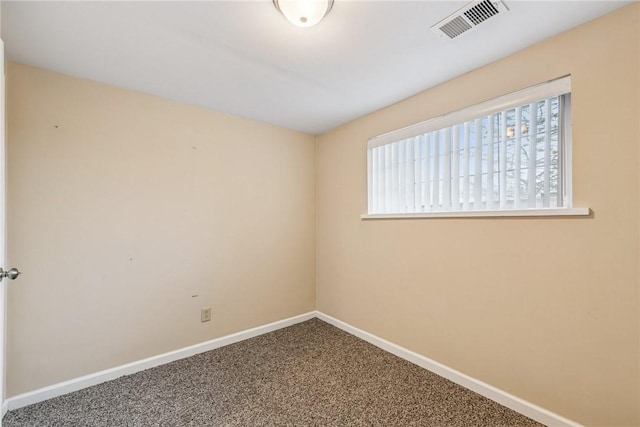 empty room with carpet floors, visible vents, and baseboards