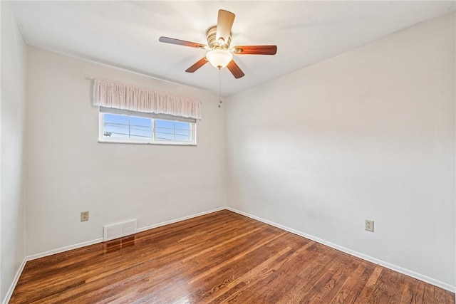 empty room featuring baseboards, ceiling fan, visible vents, and wood finished floors