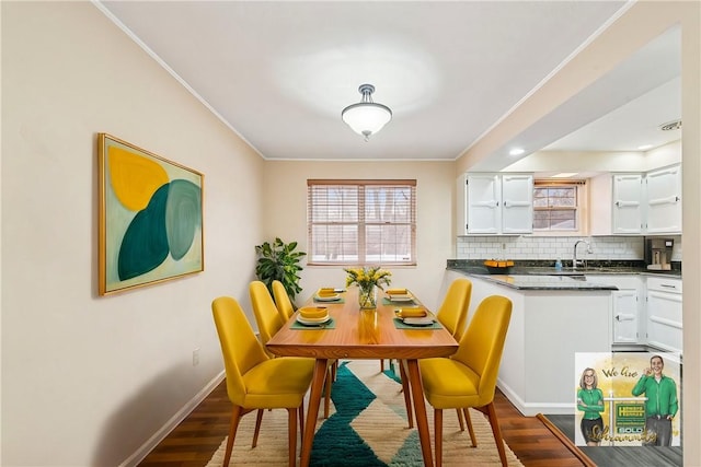 dining space with baseboards, dark wood-type flooring, visible vents, and crown molding