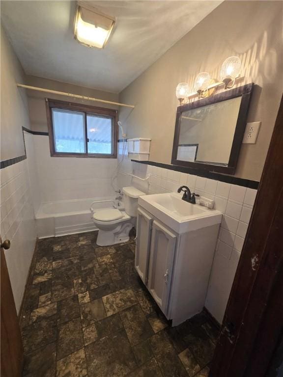 bathroom with toilet, washtub / shower combination, tile walls, and vanity