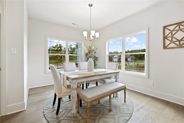 dining space with visible vents, plenty of natural light, and wood finished floors