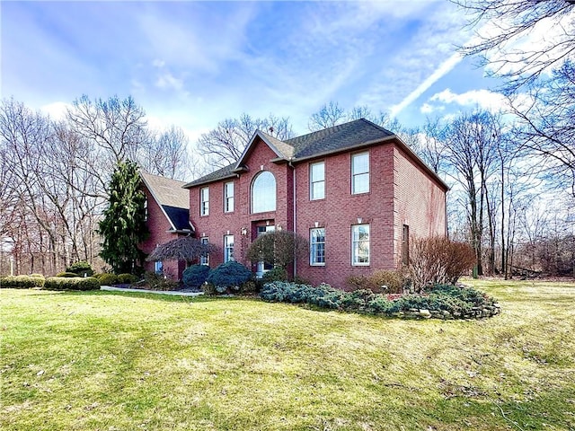 colonial-style house with brick siding and a front lawn