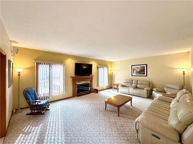 carpeted living room featuring a textured ceiling, a fireplace, and baseboards