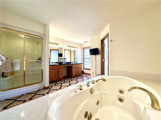 full bath featuring a textured ceiling, a jetted tub, vanity, and a stall shower